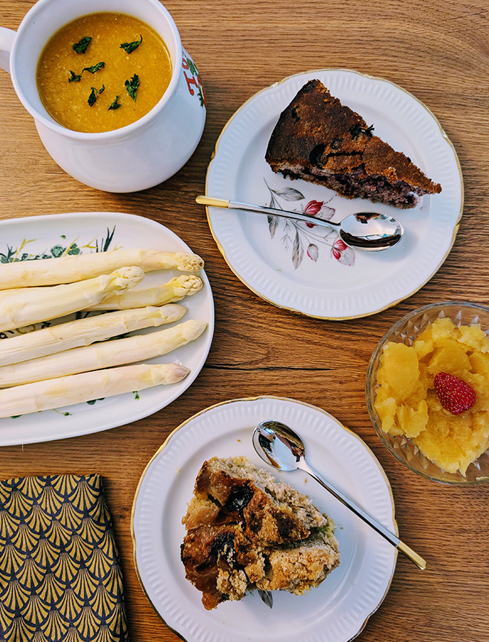 Plateau de batch cooking avec des asperges blanches, un velouté de légumes, un crumble aux fruits, un gâteau maison et une salade d'ananas.
