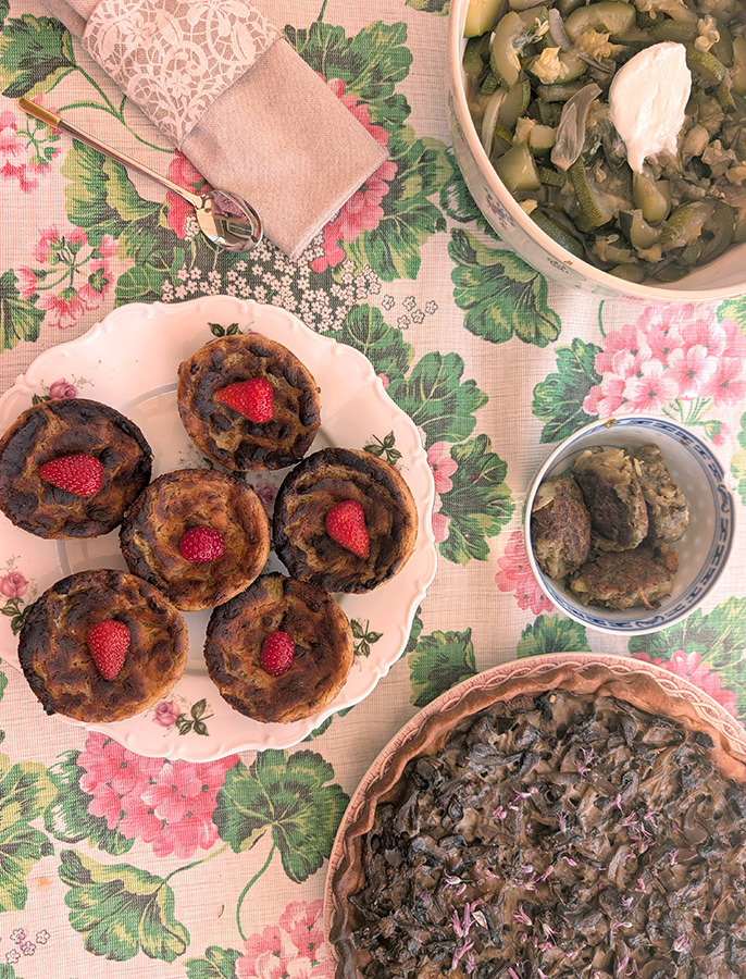 Menu de batch cooking composé d'une quiche aux champignons, de flans de légumes individuels, de boulettes végétales et d'une poêlée de légumes verts.